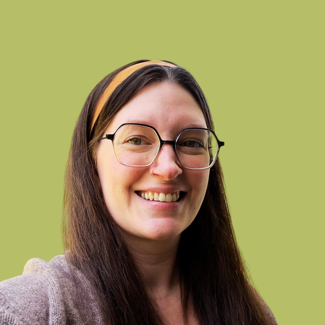 Rachel Kaur smiling, wearing glasses and an orange headband